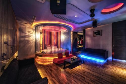 a room with a bed and a couch and lights at Bali Motel - Zhongli in Zhongli