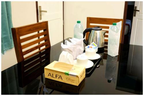 a table with a pizza box and a tea kettle at Vajra Periyar Heritage in Alwaye