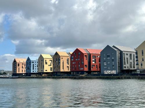 a row of buildings next to a body of water at Le Cottage Malouin in Dunkerque