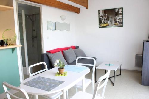 - un petit salon avec une table et des chaises blanches dans l'établissement Appt studio mezza LA ROCHELLE - LR020-316, à La Rochelle
