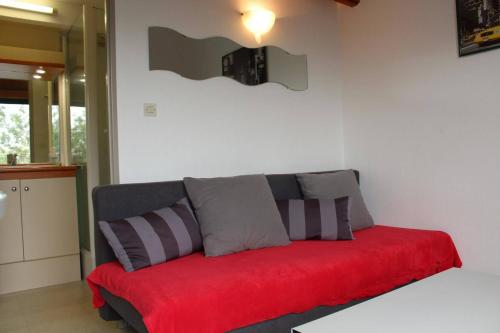 - un canapé rouge dans le salon dans l'établissement Appt studio mezza LA ROCHELLE - LR020-316, à La Rochelle