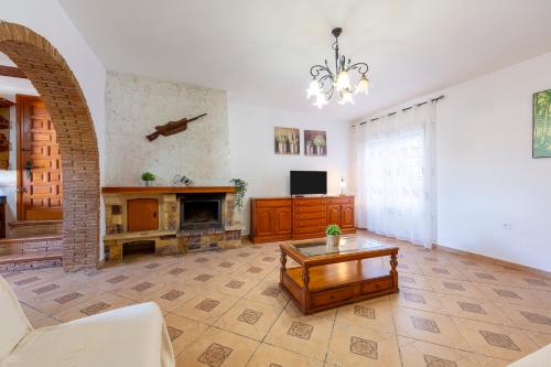 a living room with a fireplace and a chandelier at La Tierra in Níjar