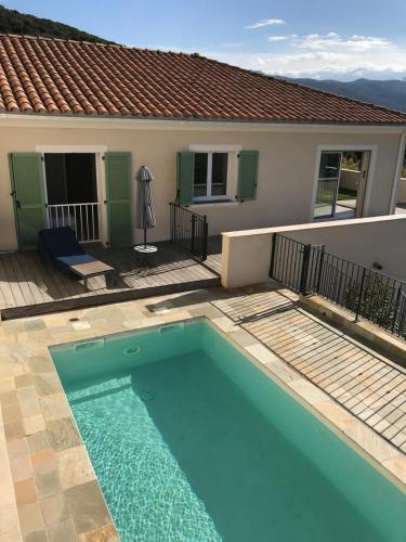 une piscine devant une maison dans l'établissement Villa de standing Vista - Piscine - Vue Lac de Padula, à Oletta