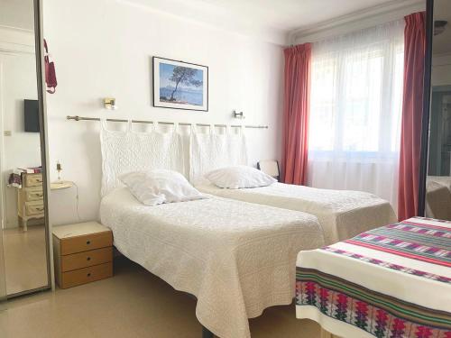 une chambre d'hôtel avec deux lits et un miroir dans l'établissement Charming Apartment in the Heart of Cannes - 10 Minutes walk to La Croisette, à Cannes