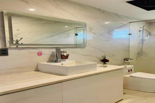 a white bathroom with a sink and a toilet at BonBon Villa & Coffee in Bảo Lâm