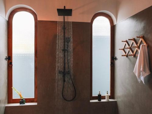 a shower in a bathroom with two windows at Guava House Ahangama two bed room villa with swimming pool in Ahangama