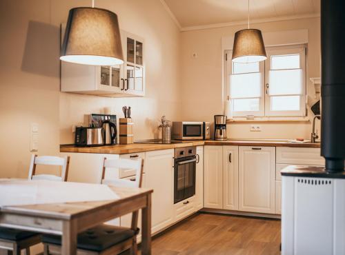 a kitchen with white cabinets and a table at Ferienhaus Oberspreewald in Schwielochsee