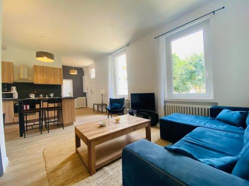 un salon avec un canapé bleu et une table dans l'établissement Casa du Mail, à Angers