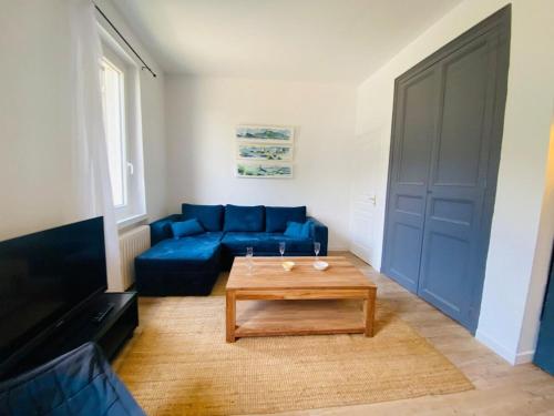 un salon avec un canapé bleu et une table basse dans l'établissement Casa du Mail, à Angers