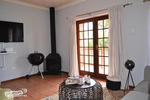 a living room with a fireplace and a couch and a table at The Yems in Dullstroom