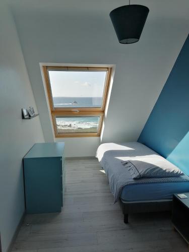 une chambre avec un lit et une fenêtre dans l'établissement La maison de la plage 4 étoiles en front de mer SPA intérieur GR34, à Plouarzel