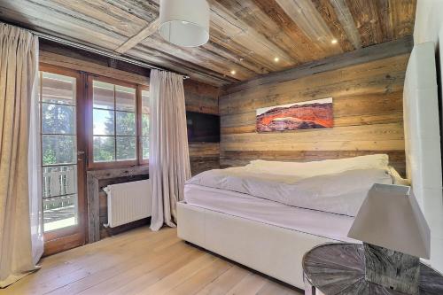 a bedroom with a bed and a wooden wall at Les Pives in Icogne