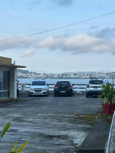 three cars parked in a parking lot near the water at Hotel Veleiro in Florianópolis