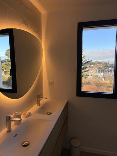 La salle de bains est pourvue d'un lavabo, d'un miroir et de 2 fenêtres. dans l'établissement Magnifique villa avec piscine à deux pas du port, à Pléneuf-Val-André