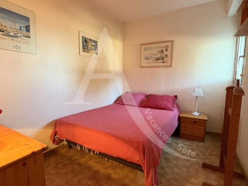 une chambre avec un lit et une table avec une lampe dans l'établissement T2 PARKING ACCES DIRECT AUX PLAGES, à Sète