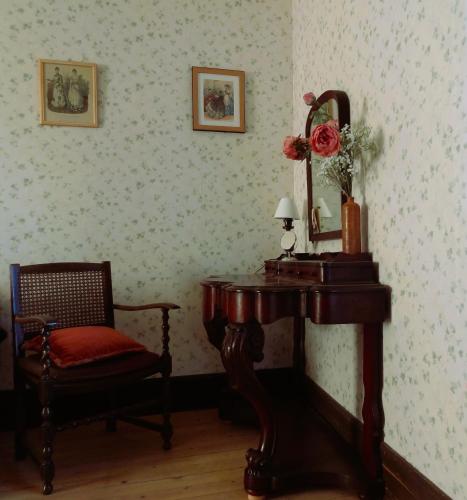 a room with a table and a chair and a mirror at Maison p'tite Anne in Arleuf