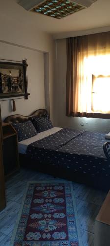 a bedroom with two beds and a window and a rug at İmperial Hotel in Konak