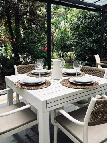 - une table blanche avec des assiettes et des verres sur la terrasse dans l'établissement Casa Regina - Spacieux appartement près de la Sorgue, à LʼIsle-sur-la-Sorgue