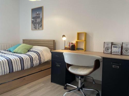 une chambre avec un lit et un bureau avec une chaise dans l'établissement Appt 2 pièces LA ROCHELLE - LR090-D122, à La Rochelle