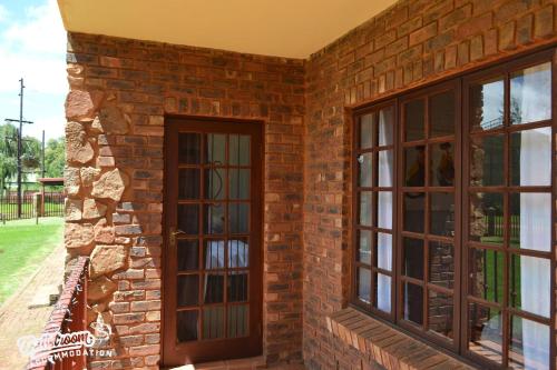 a brick wall with two windows on it at The Yems in Dullstroom