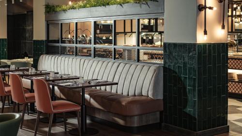 a restaurant with a long bench in the middle at AX ODYCY Hotel in St Paul's Bay