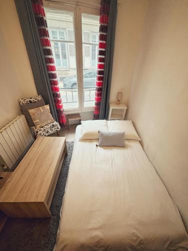 une petite chambre avec deux lits et une fenêtre dans l'établissement Studio en plein coeur de Fontainebleau, château à 3 minutes à pieds, à Fontainebleau