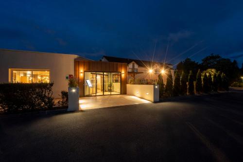 a house with a driveway at night at Sure Hotel by Best Western Caen Memorial in Caen