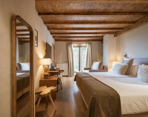 a hotel room with a large bed and a mirror at The Mountains Hotel in Sierra Nevada