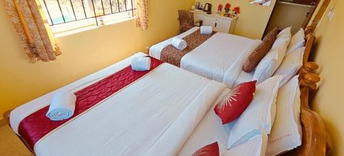 two beds sitting next to each other in a bedroom at Kodai Hillscape in Kodaikānāl