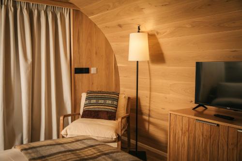 a bedroom with a bed and a tv and a chair at Bracken Hide Hotel in Portree