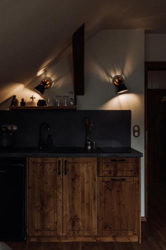 a kitchen with wooden cabinets and a black counter top at Apartmány Lešovice in Netschetin