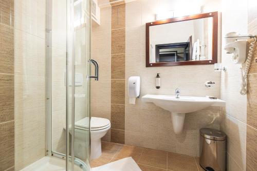 a bathroom with a toilet and a sink and a mirror at Aria by Brilliant in Zalău