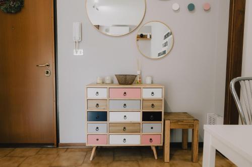 - une commode avec un miroir à côté d'une table dans l'établissement La Serra Apartment with balcony, à Vérone