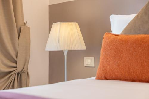 a bedroom with a bed with a lamp and a window at Palazzo Indelli in Monopoli