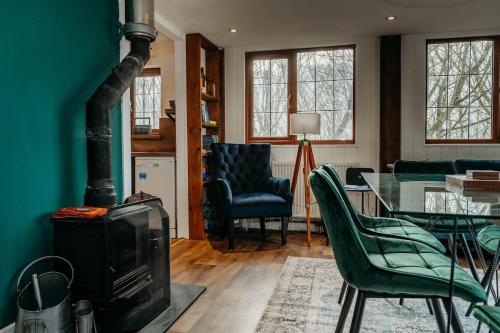 a living room with a fireplace and a table and chairs at Heron's Perch- A pond-side retreat with cinema room in Callington