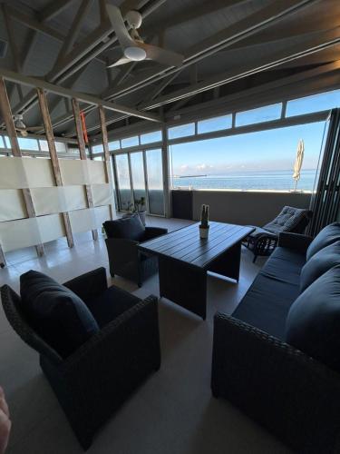 a living room with couches and a table and the ocean at Loft 181 by Oikies Rentals in Neoi Epivates