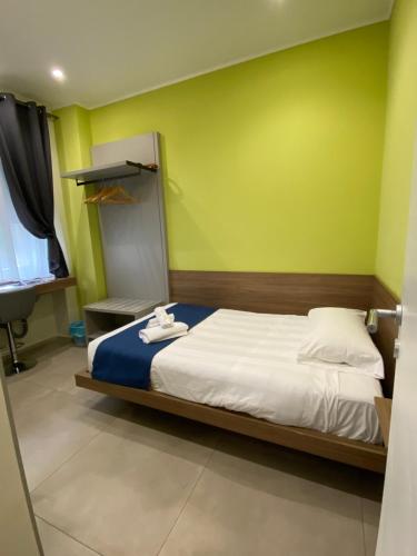 a bedroom with a bed and a green wall at Levante apartment and room in Bari