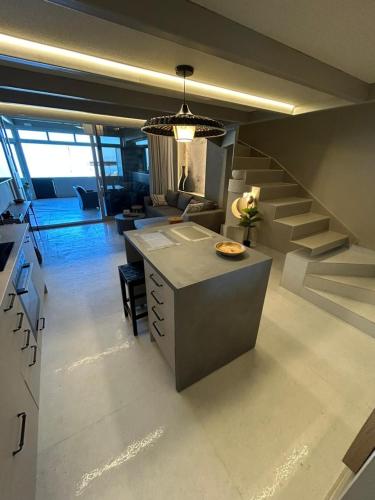 a kitchen and a living room with a staircase at Loft 181 by Oikies Rentals in Neoi Epivates