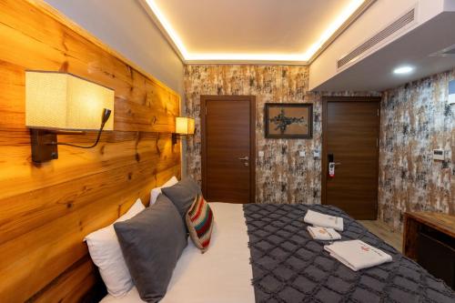 Un dormitorio con una cama y una pared de madera. en Double DD Hotel, en Estambul