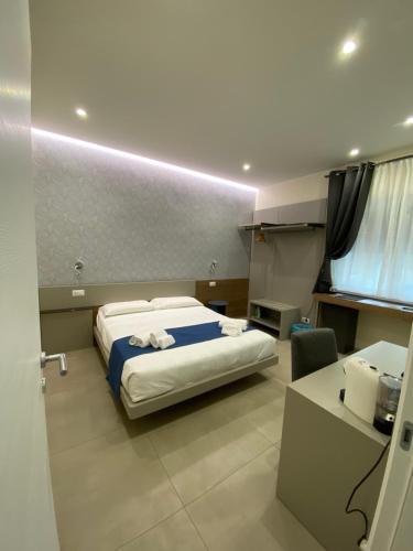 a hotel room with a bed and a desk and a desk at Levante apartment and room in Bari