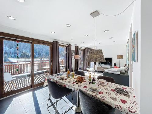 une salle à manger avec une table et des chaises et un balcon dans l'établissement Kotibe- Les Gets - Les Perrieres, aux Gets