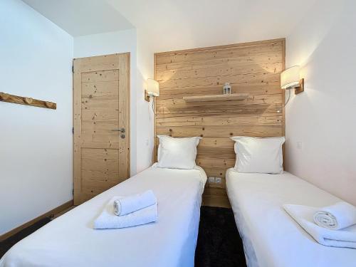 deux lits côte à côte dans une pièce dans l'établissement Kotibe- Les Gets - Les Perrieres, aux Gets