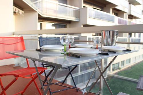 une table avec des assiettes et des verres à vin sur un balcon dans l'établissement Appt 2 pièces LA ROCHELLE - LR660-116, à La Rochelle