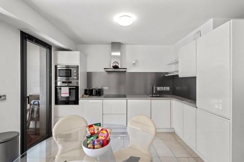 une cuisine avec des armoires blanches et une table et des chaises dans l'établissement Cannes Croisette 2 bedrooms - 7C3, à Cannes
