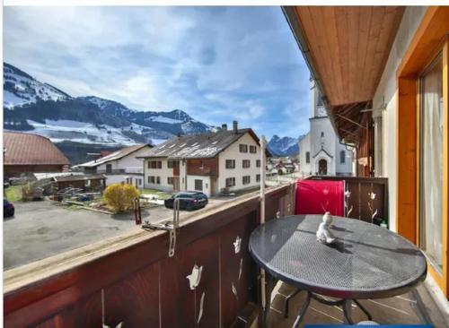 a balcony with a table and a view of a mountain at Cozy Apartment in Haut-Intyamon with Garden 75 m² in Albeuve