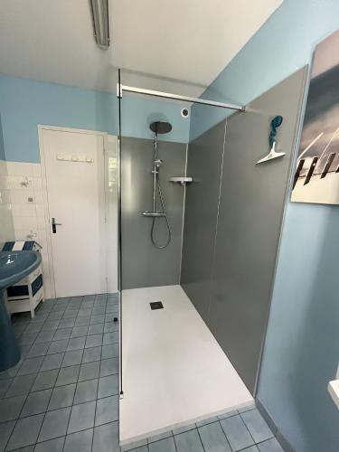 une douche avec une porte vitrée dans une salle de bain dans l'établissement Les Floralies, à La Tranche-sur-Mer