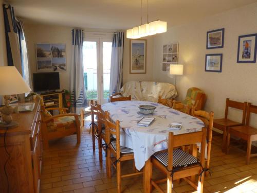 a kitchen and living room with a table and chairs at Les Floralies in La Tranche-sur-Mer