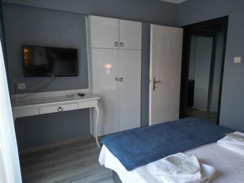a bedroom with a bed and a tv on a wall at Akman City Hotel in Kusadası