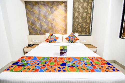 a bedroom with a bed with a colorful quilt on it at FabExpress Marvel Bliss - Nr Trump Towers in Pune