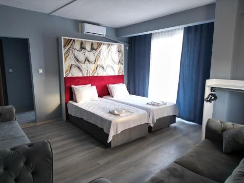a bedroom with a bed with a painting on the wall at Akman City Hotel in Kusadası